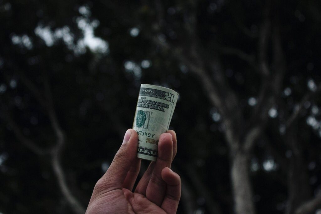 Someone holding money to show a pay raise gecko hospitality